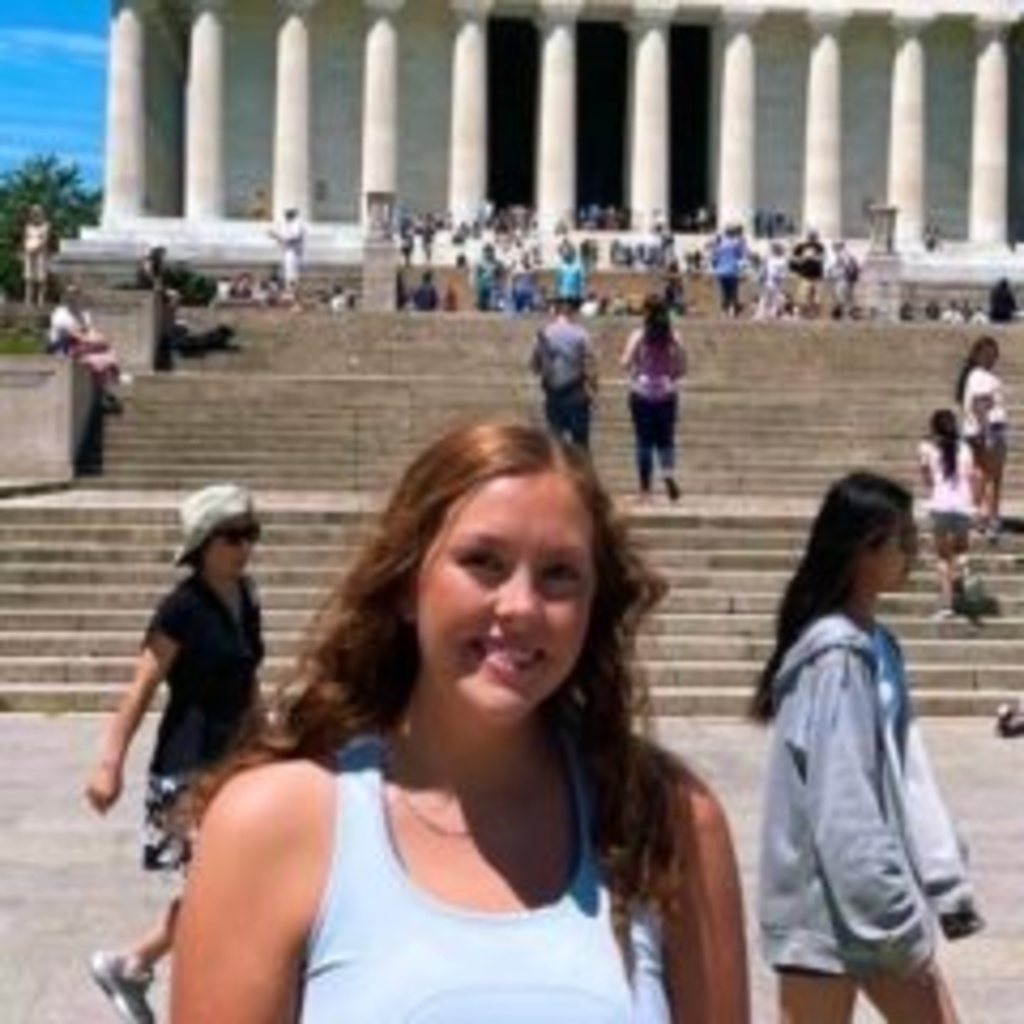 Picture of Liz Barnett smiling in front of a monument with stairs.