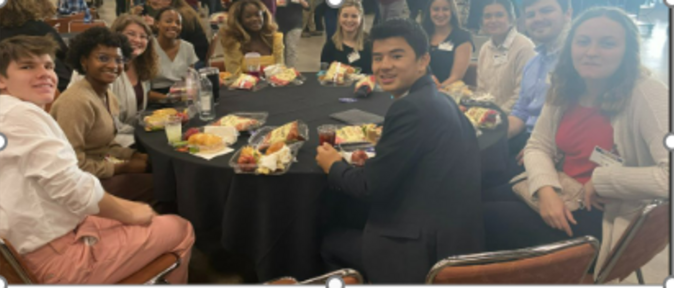 Original CRATERS team sitting at a round table, 10 team members smiling at camera dressed in business attire 