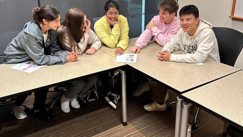 4 teens sitting around a table working together